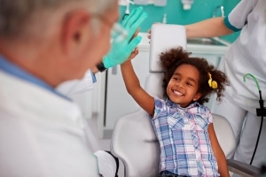 child high-fiving a dentist