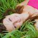 Woman smiling in grass, representing confidence and the benefits of cosmetic bonding for an enhanced smile.