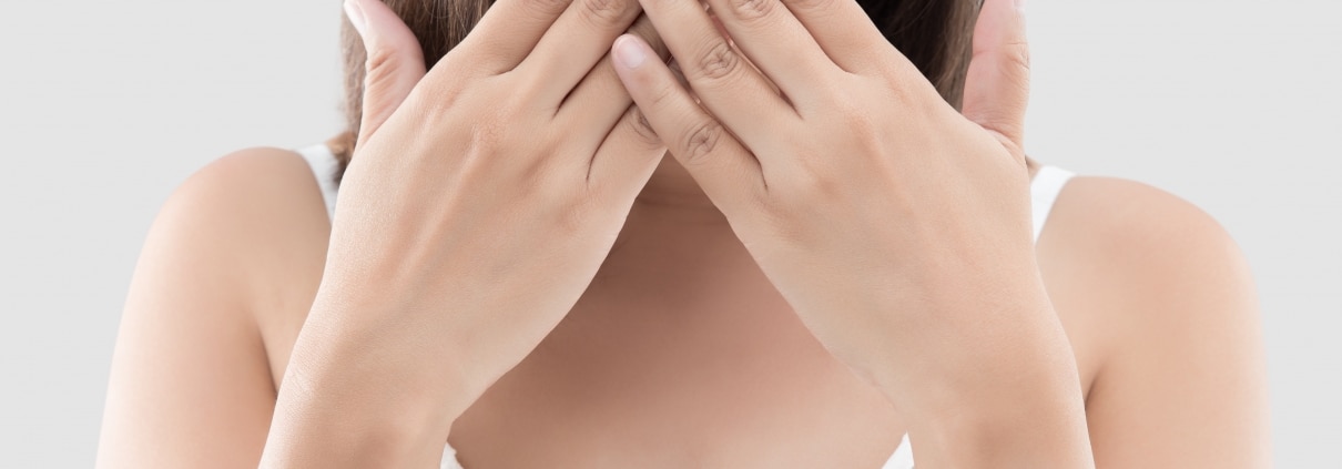 woman covering her mouth to hide her stained teeth