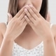 woman covering her mouth to hide her stained teeth