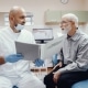Older man siting with his dentist discussing treatment
