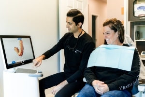 Dr. Desai with patient showing the 3D model of her bottom arch of teeth