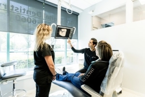 Dr. Desai and dental assistant showing the patient her dental X-rays