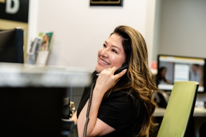 front desk staff answering the phone while smiling