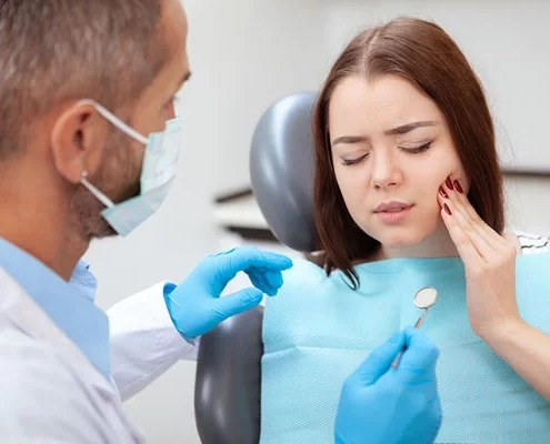 young lady showing pain discomfort while on the dental chair