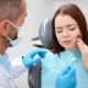 young lady showing pain discomfort while on the dental chair